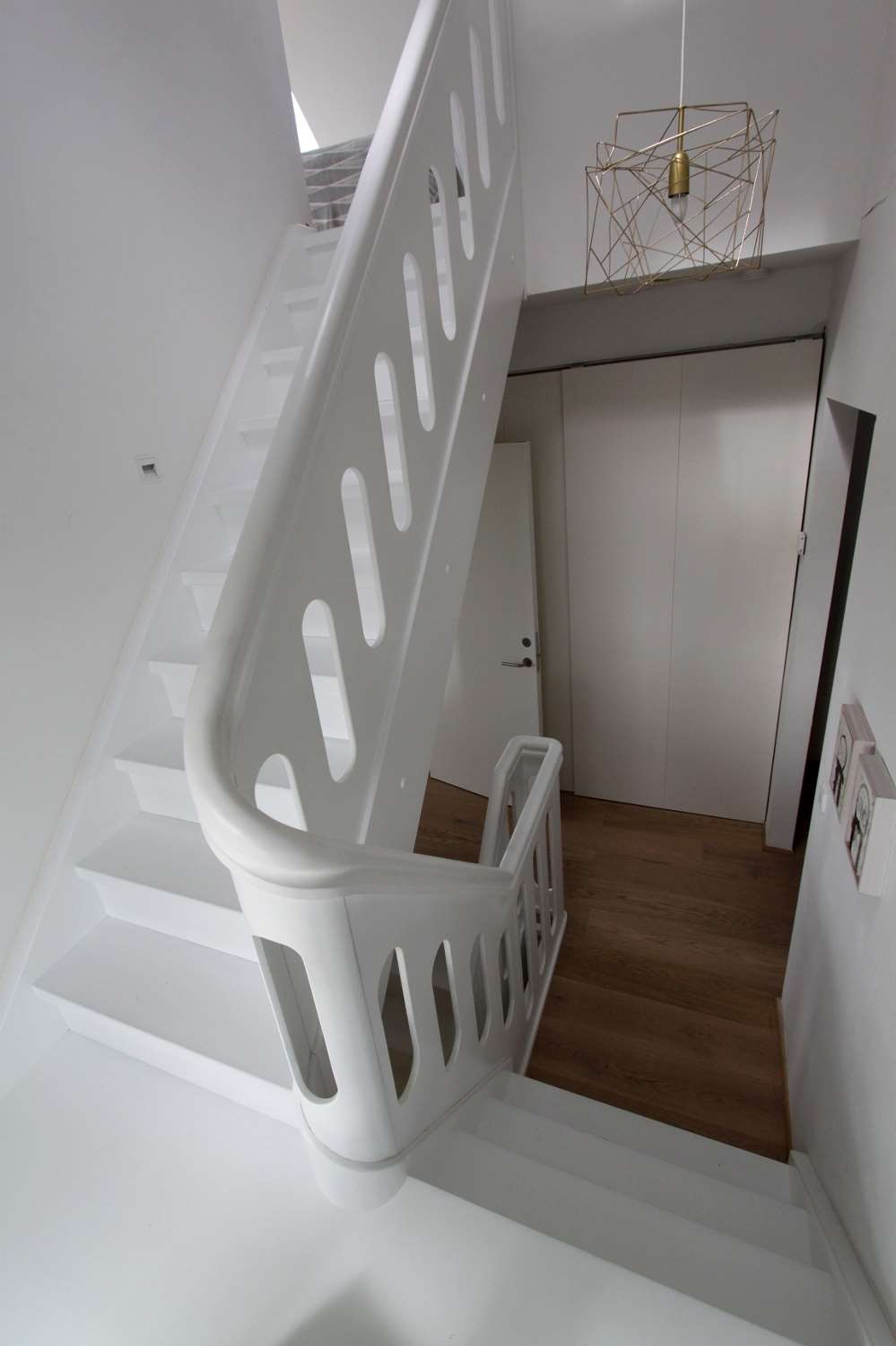 Hvidmalet trappe med udskåret pladegelænder og repos