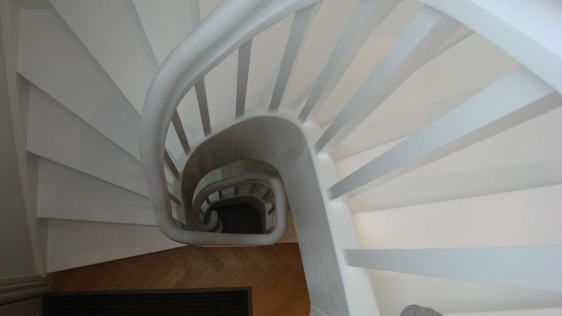Hvidmalede trapper som svinger fra kælder til 1. sal
